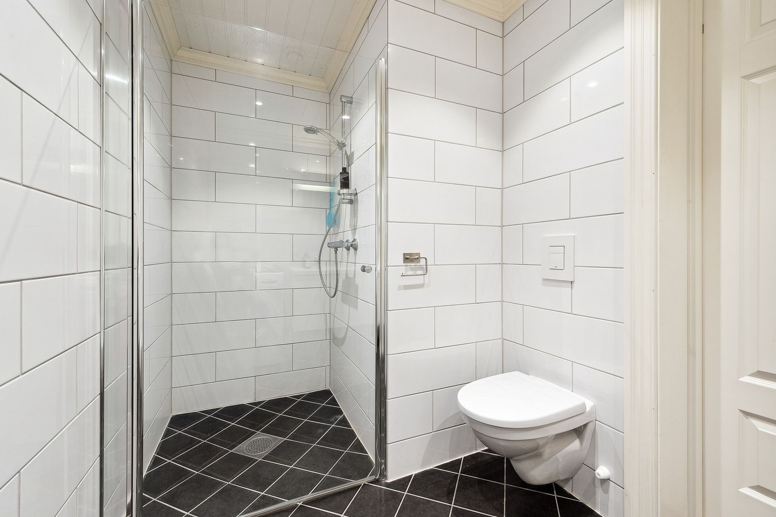 Praktisk og plassbesparende dusjnisje med dusjdør i herdet glass. Galleribilde