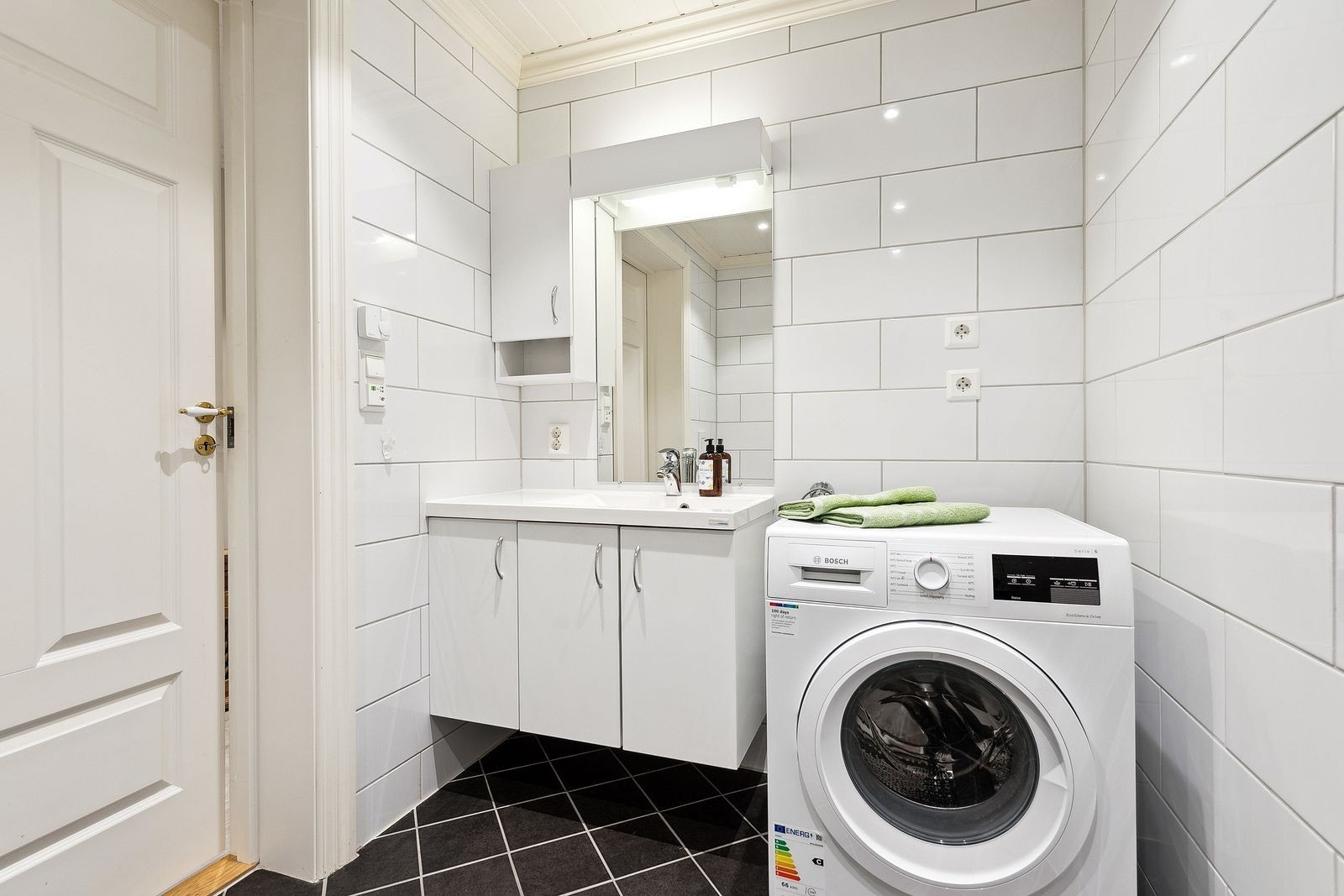 Baderom i sokkelleilighet med opplegg for vaskemaskin og samme standard som man finner i resten av boligen. Galleribilde