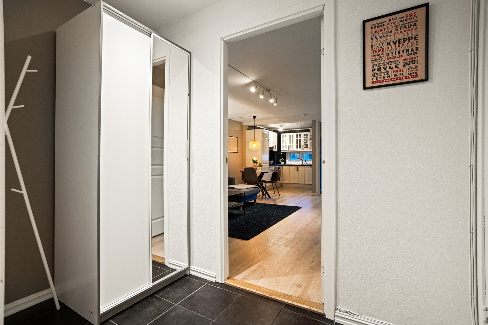 I entreen er det også en hvit skyvedørsgarderobe med dels speilfronter, hvor jakkene kan henges bort Galleribilde