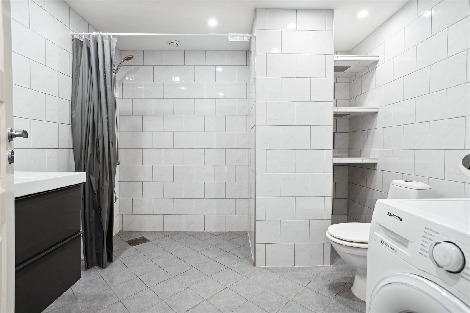 U-etasje, utleiedel (del av egen bolig): Badet inneholder toalett, dusj, opplegg for vaskemaskin og baderomsinnredning med servant og overhengende speil. Galleribilde