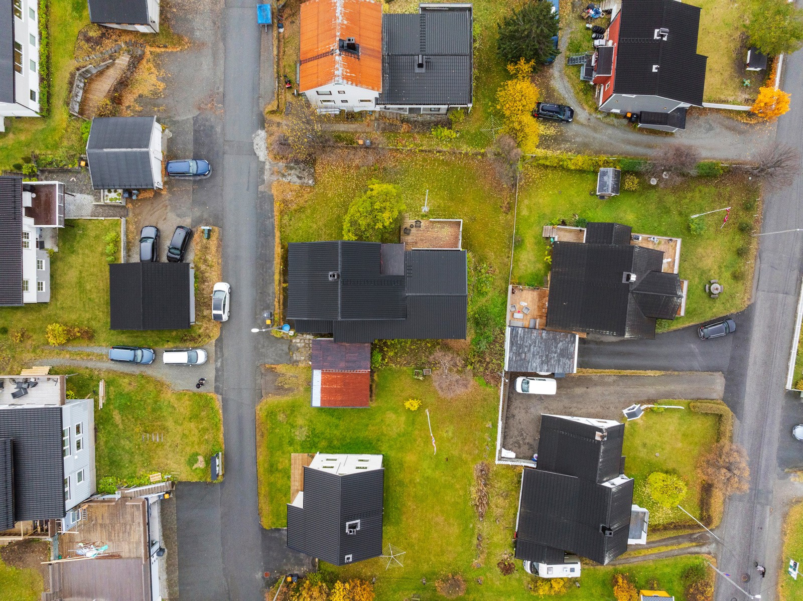 Oversiktsbilde. Tomta omgrenses av hage mot sør og vest, mot nord går grensen igjennom garasjene mot nord (skilles v. rødt tak).