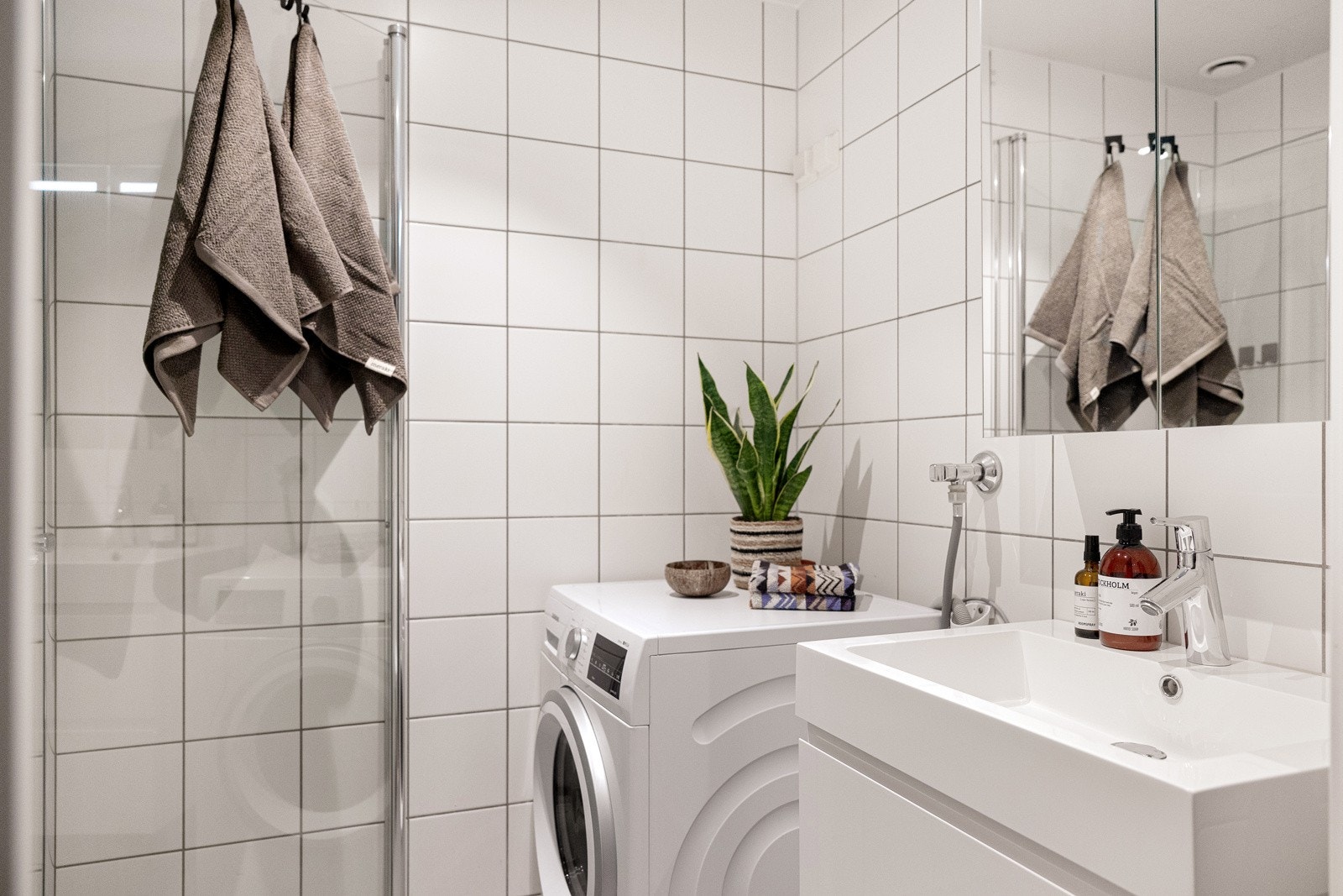 Lyst og tidløst baderom fra byggeår med gulvvarme i baderommet for en komfortabel gulvvarme året rundt. Det er også opplegg for vaskemaskin samt et veggmontert klosett. Galleribilde