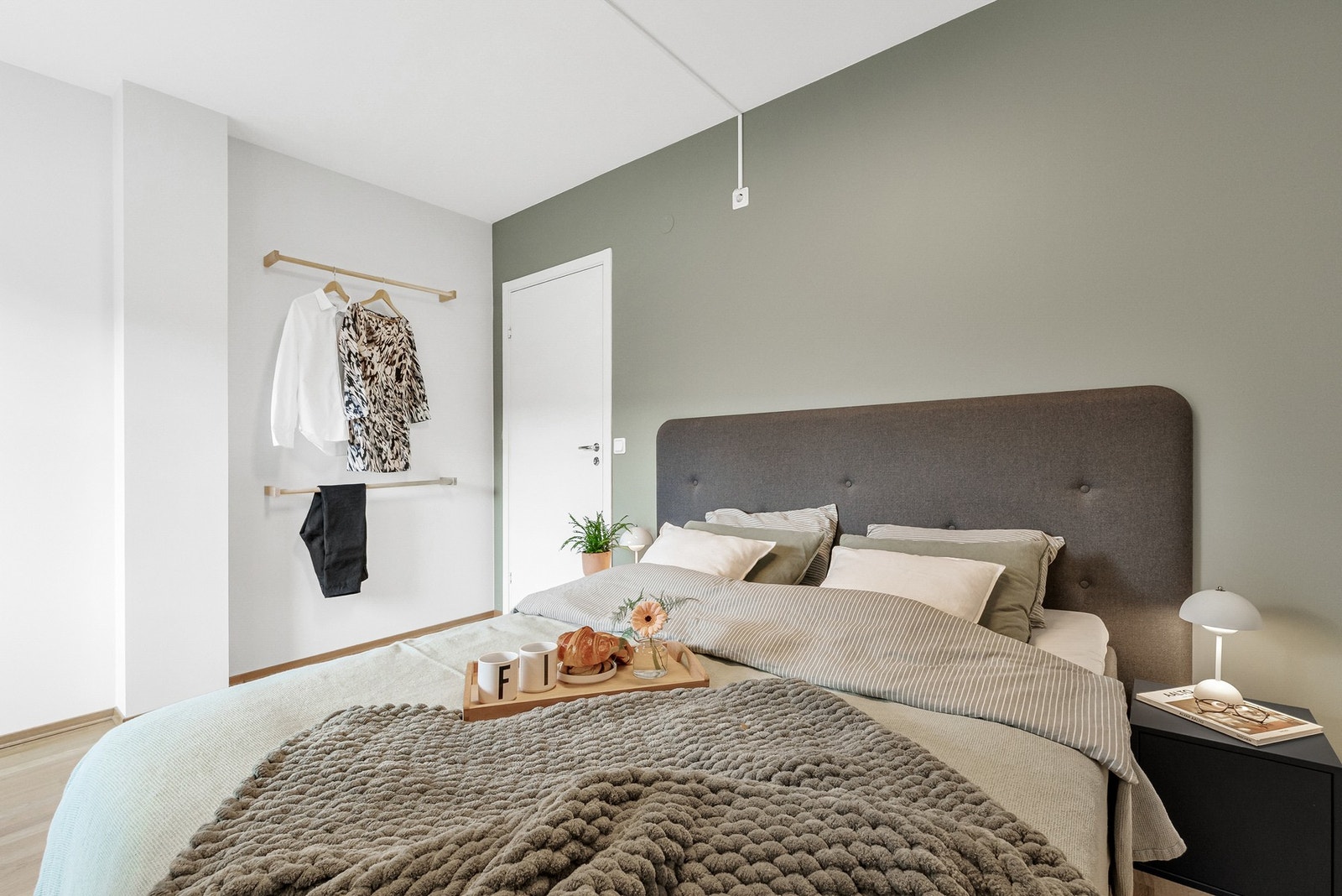 Den stilrene grønne kontrastveggen gir en lun og harmonisk atmosfære, perfekt balansert med lyse vegger som fremhever rommets gode størrelse. Galleribilde