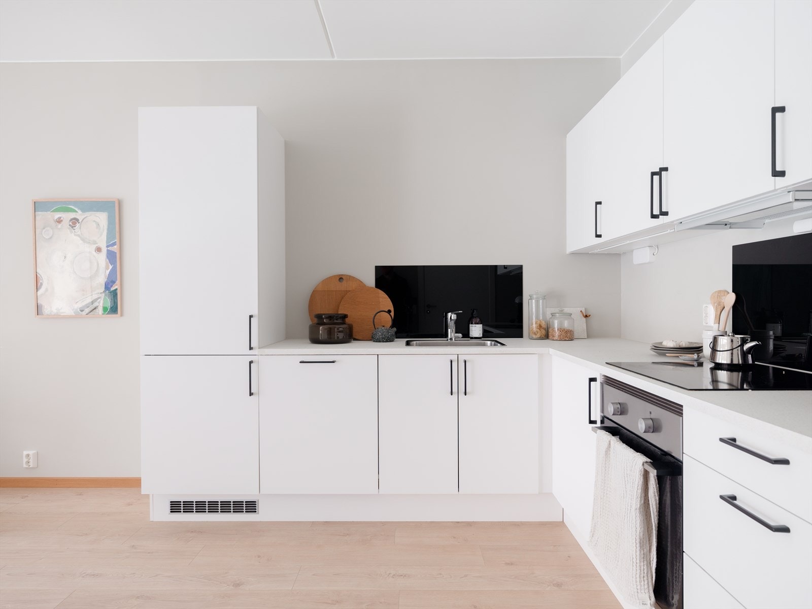 Kjøkkeninnredningen har et tidsløst og elegant uttrykk med slette overflater og laminert benkeplate. Galleribilde