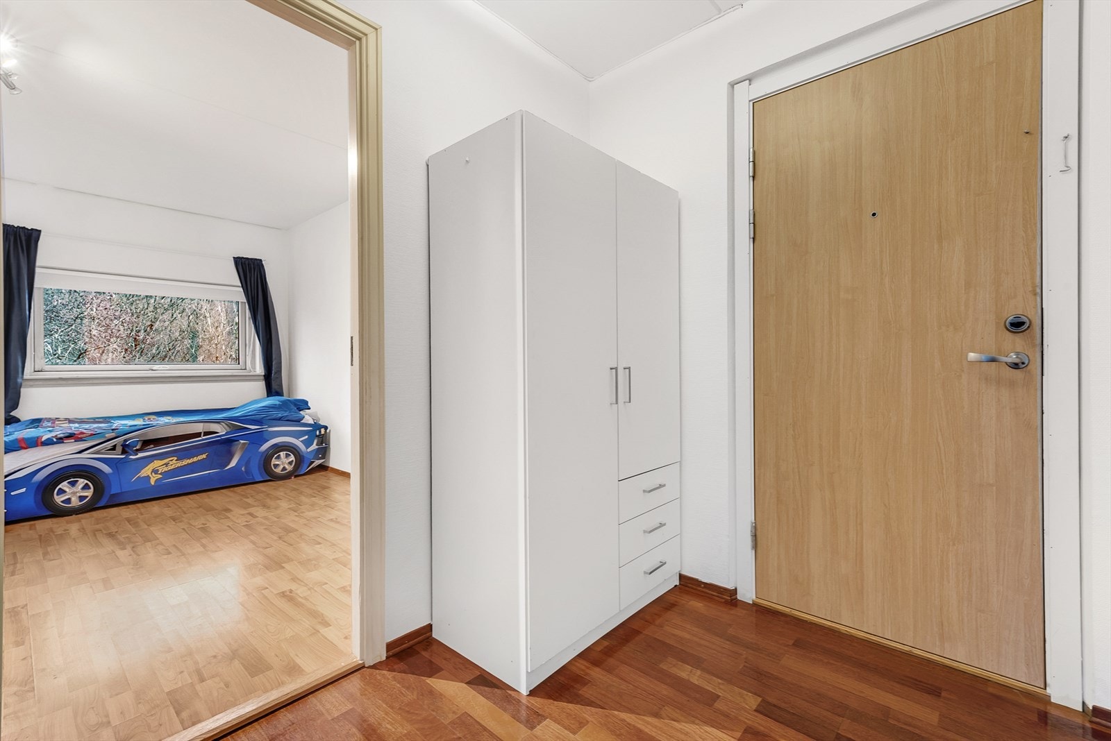 Entré med parkettgulv og plass til garderobeløsning, og dør-calling fra 2024. Galleribilde