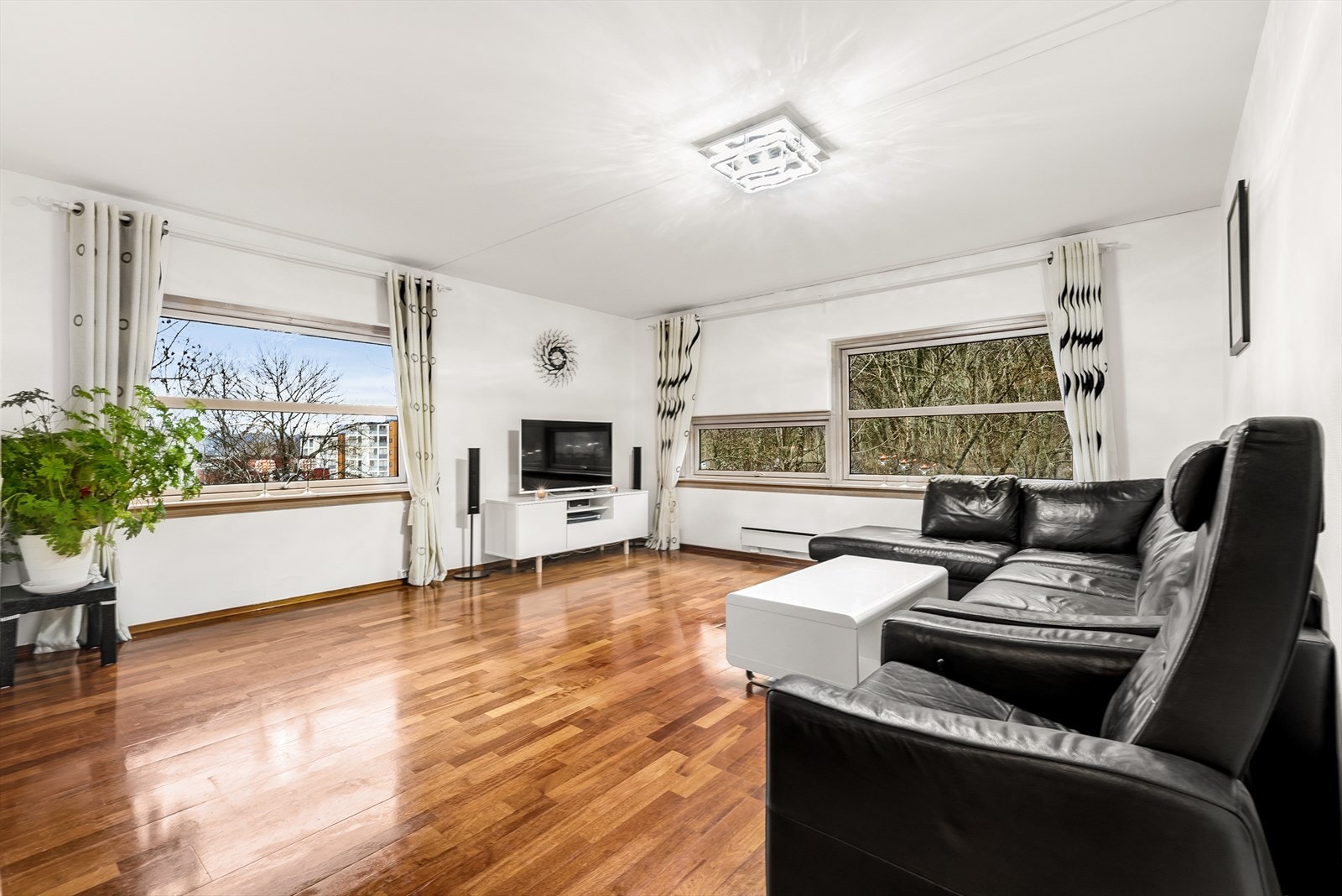 Arealeffektiv stue med store vinduer som slipper inn rikelig med lys. Galleribilde