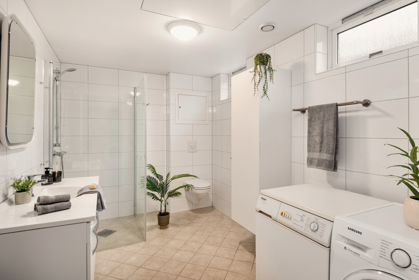 Det inneholder servant m/møblement og speil m/belysning, vegghengt toalett, dusjhjørne, og opplegg for vaskemaskin og tørketrommel. Galleribilde