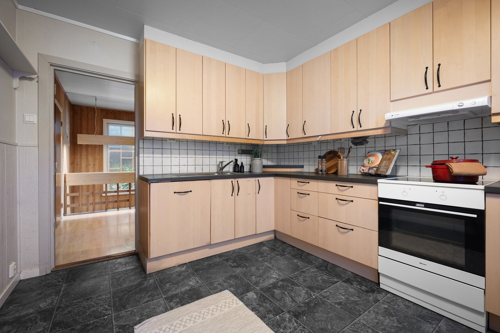 På kjøkkenet er det innredning fra IKEA med glatte fronter og benkeplate av laminat Galleribilde