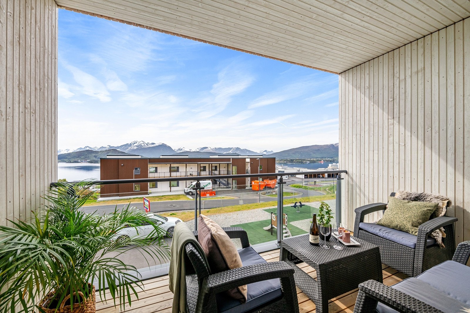 Skjermet balkong med glassrekkverk og flott utsikt mot fjord og fjell Galleribilde