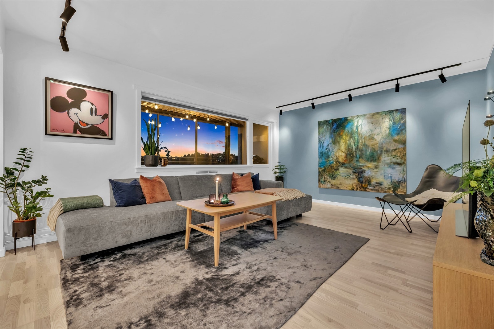 Stuen har god belysning med to moderne spotskinner i taket, i tillegg til rikelig med naturlig lys fra de store vindusflatene. Galleribilde