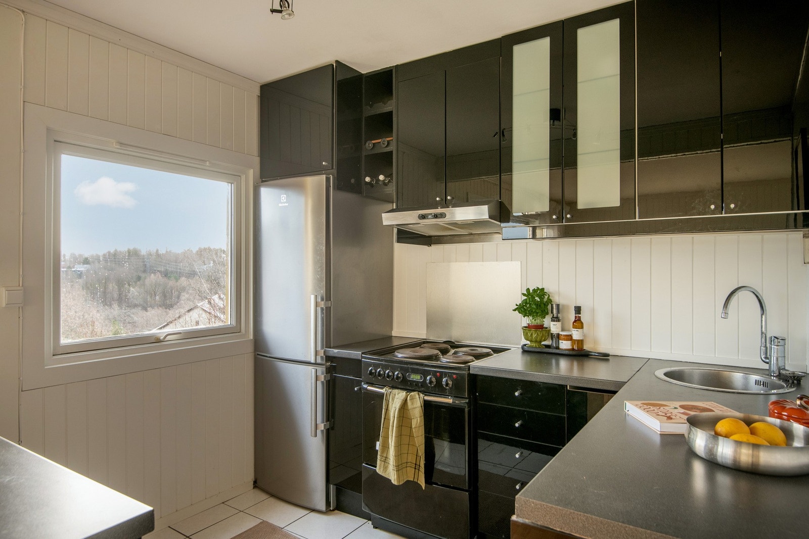 Et stort vindu slipper inn rikelig med naturlig lys og gir et flott utsyn, som både lyser opp kjøkkenet og skaper en hyggelig stemning. Galleribilde