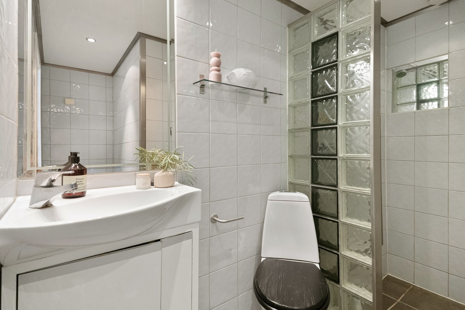 Badet er praktisk utformet med flislagte overflater som gir et stilrent og tidløst preg. Galleribilde