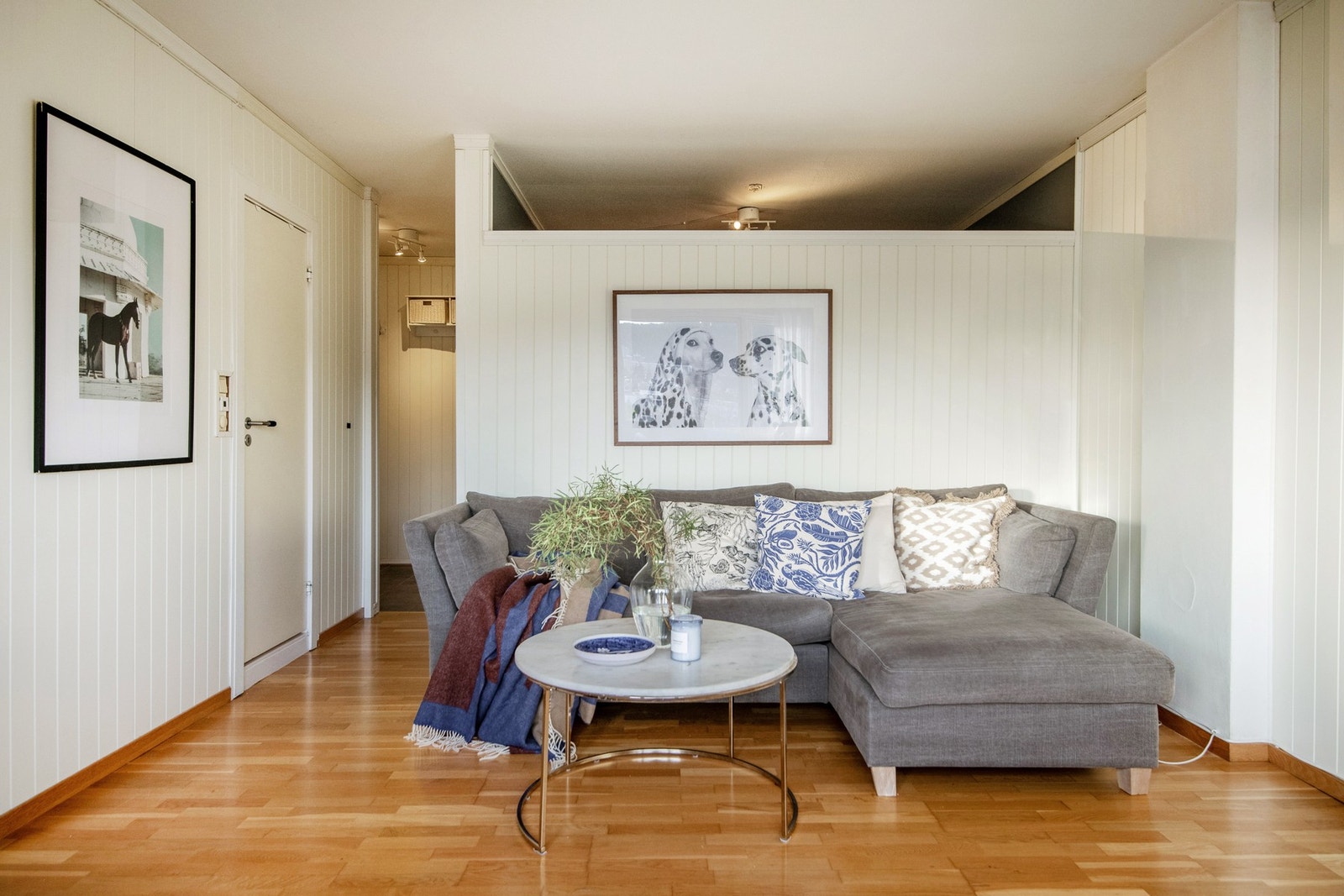 Stuen er lys og innbydende med parkett på gulvet som gir et varmt og naturlig preg, mens lysmalte veggoverflater skaper en tidløs og romslig atmosfære. Galleribilde