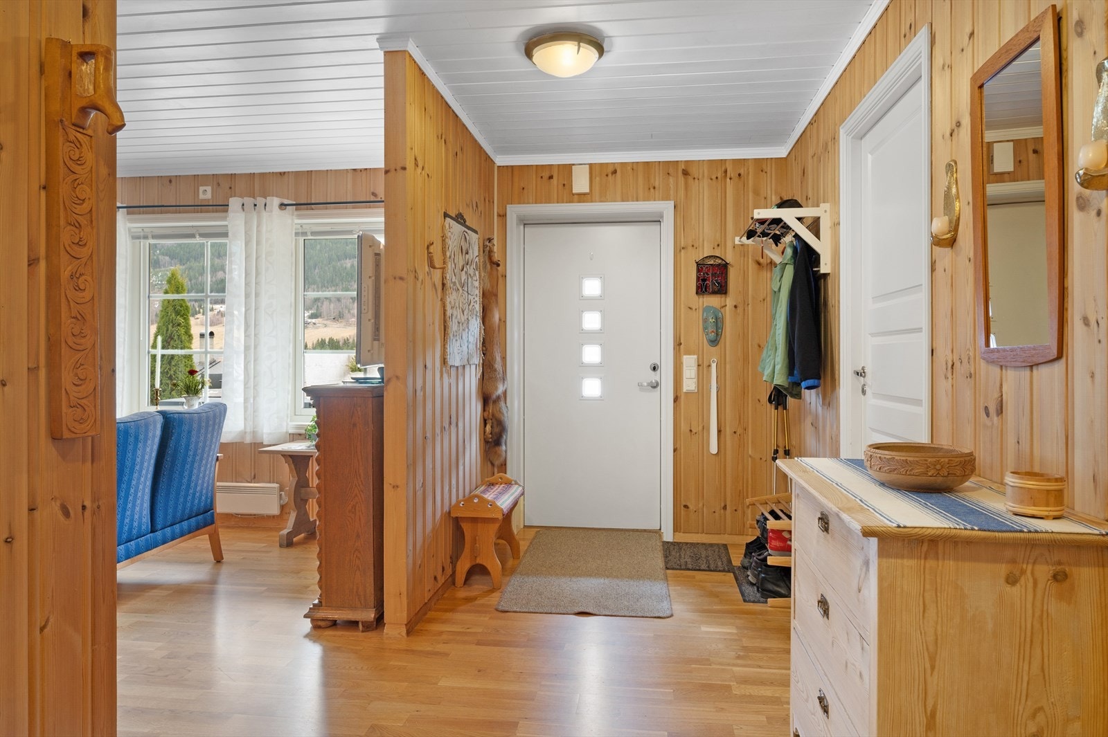 Lys og innbydende entré med naturlig treverk og praktiske oppbevaringsløsninger. Galleribilde