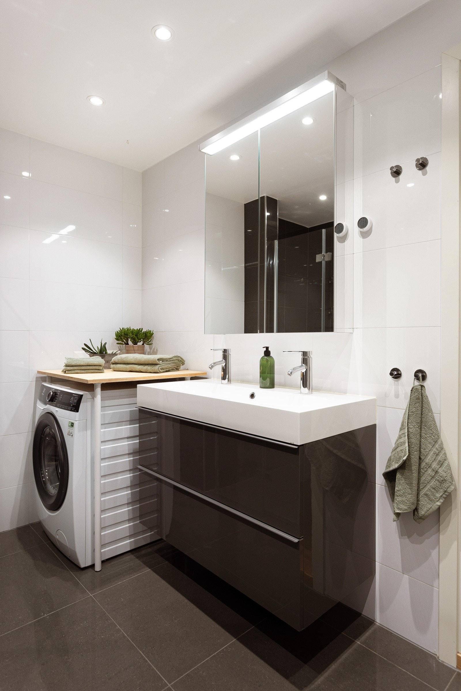 Baderomsinnredning med vegghengt servantskap, speilskap med belysning og stikkontakter over servant. Galleribilde