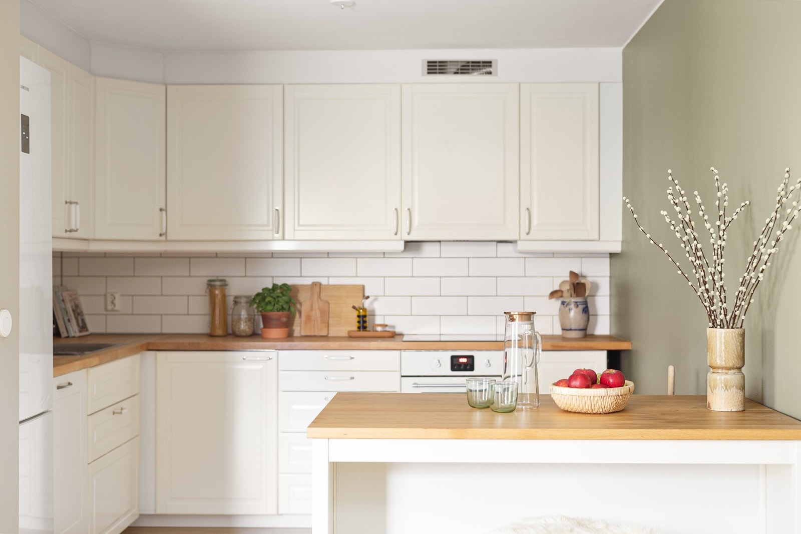 Tidløst kjøkkeninnredning fra 2014 med hvite, profilerte fronter og god skap- og benkeplass. Galleribilde