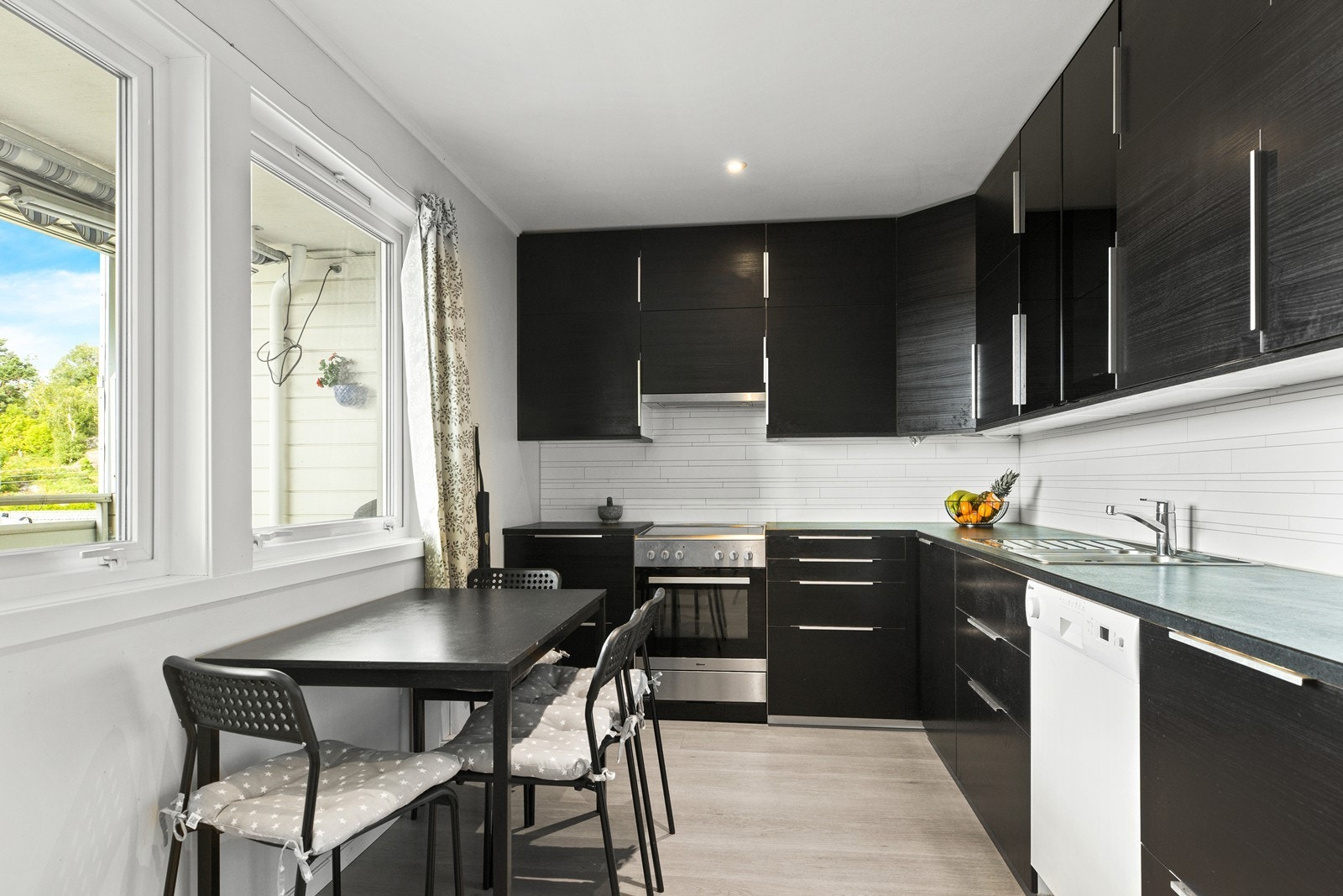 Kjøkkenet har godt med skap og skuffer til kjøkkenartikler. Det er plass til en liten spisegruppe på kjøkkenet der måltider i hverdagen kan nytes Galleribilde