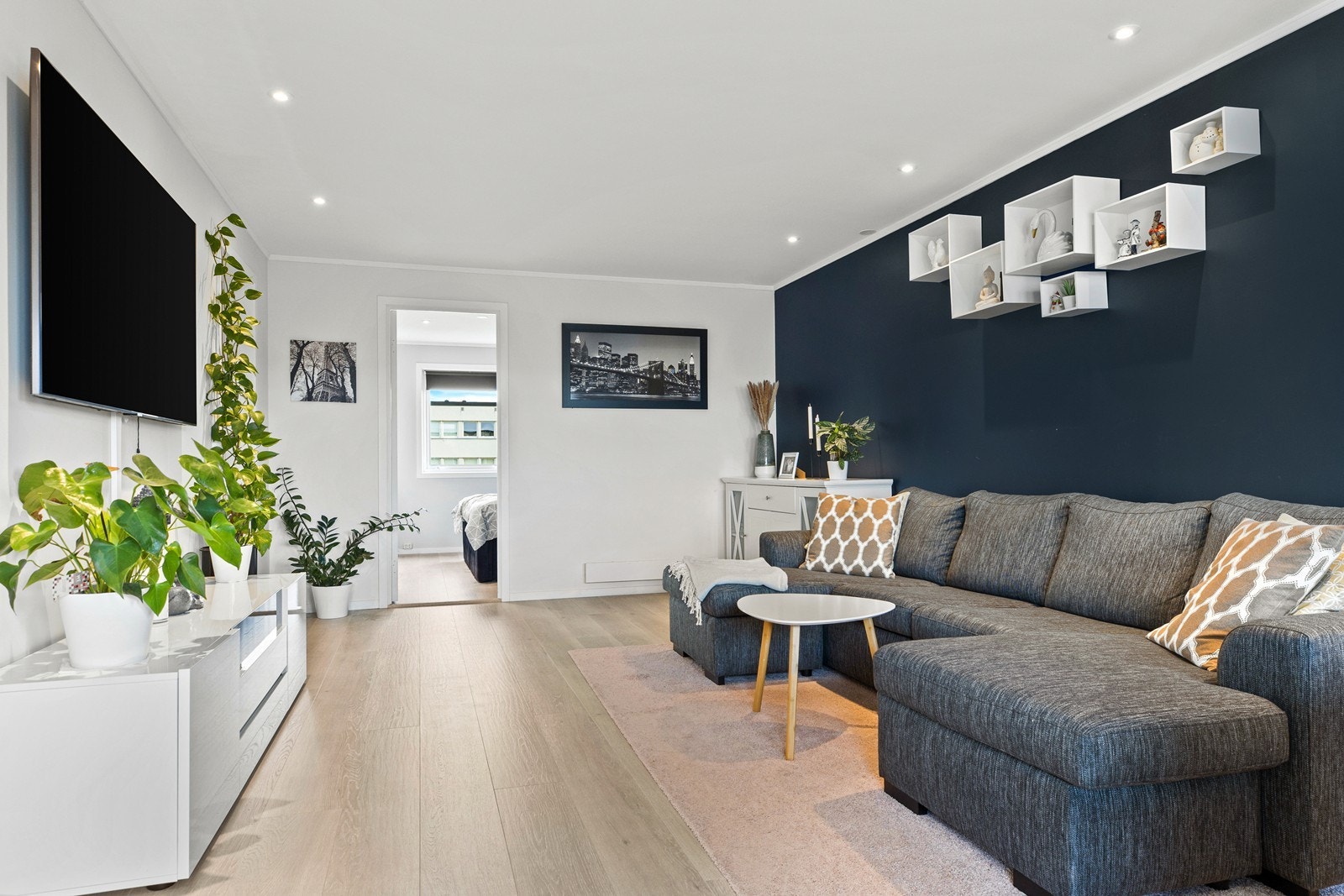 Det er adkomst til et av leilighetens to soverom fra stuen Galleribilde