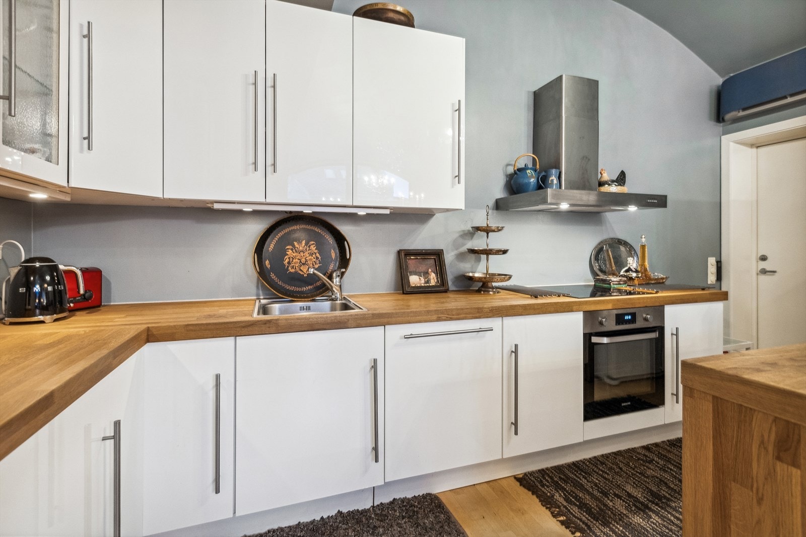 Pent kjøkken med solide benkeplater i eik, nedfelt vask og integrert komfyr + steketopp Galleribilde