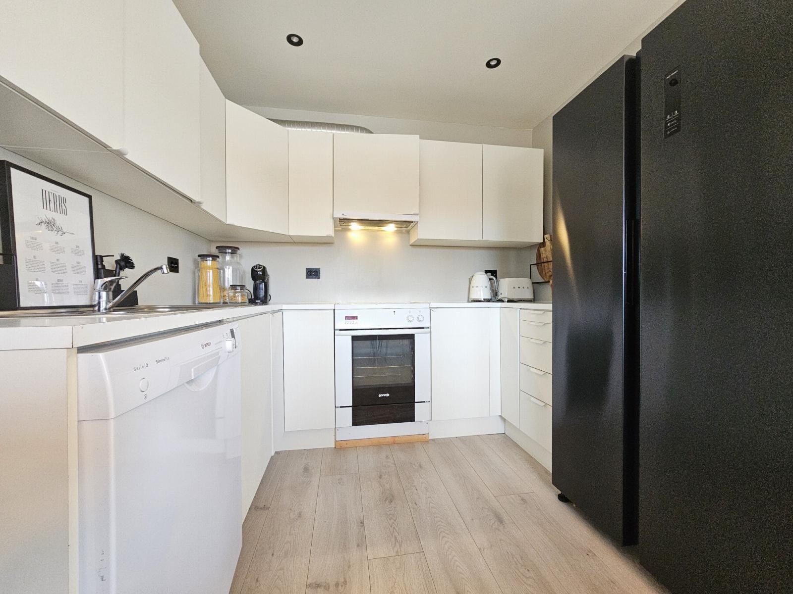 Kjøkkeninnredninga har godt med skap og benkeplass Galleribilde