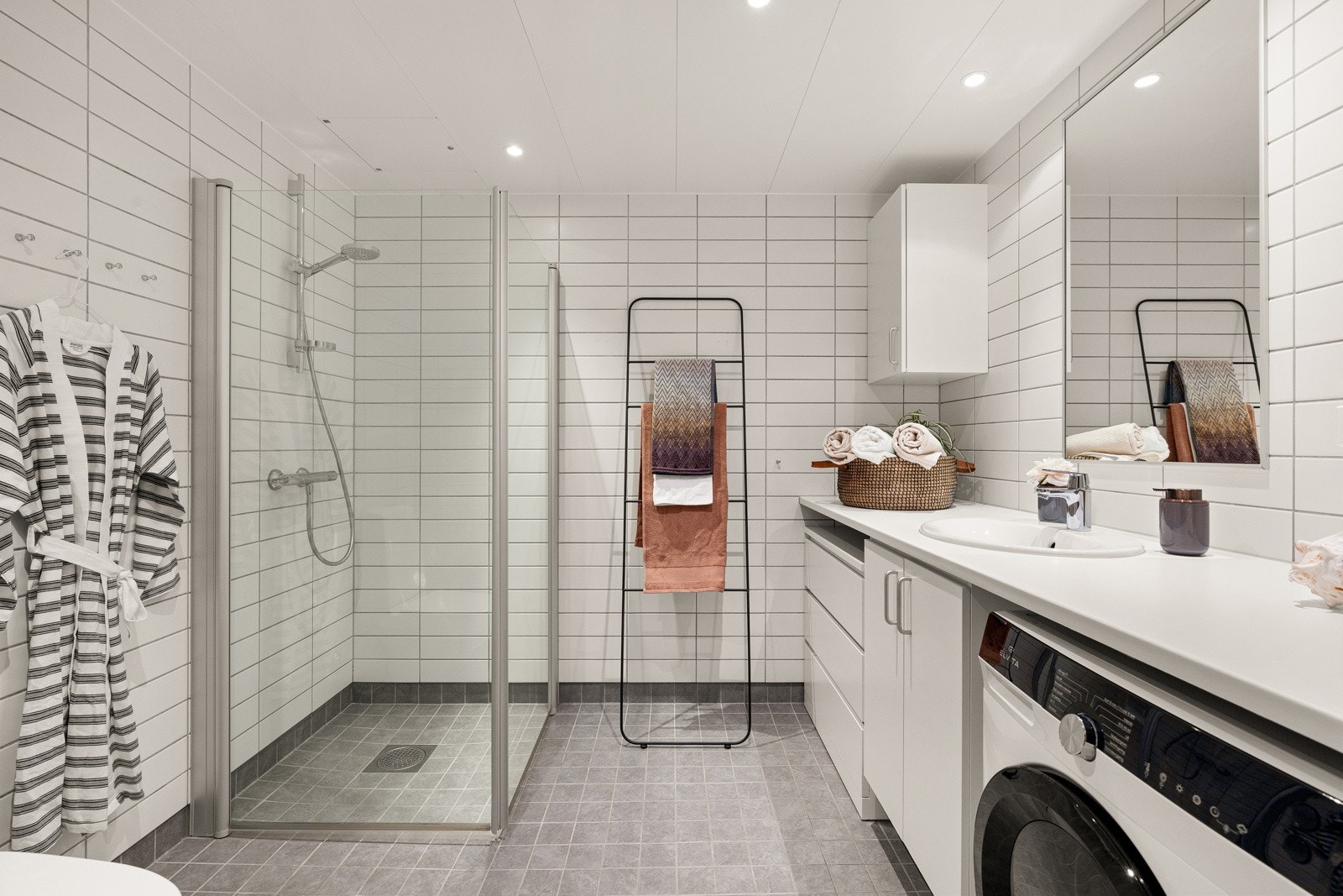 Lyst og delikat bad. Det er opplegg for vaskemaskin og tørketrommel. Galleribilde