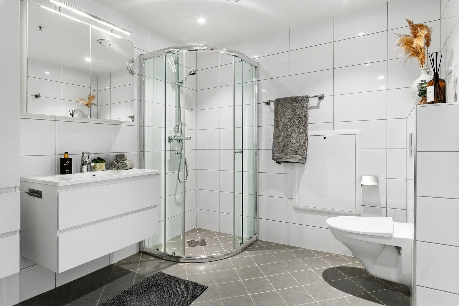 Flislagt bad med romslig baderomsinnredning. Galleribilde