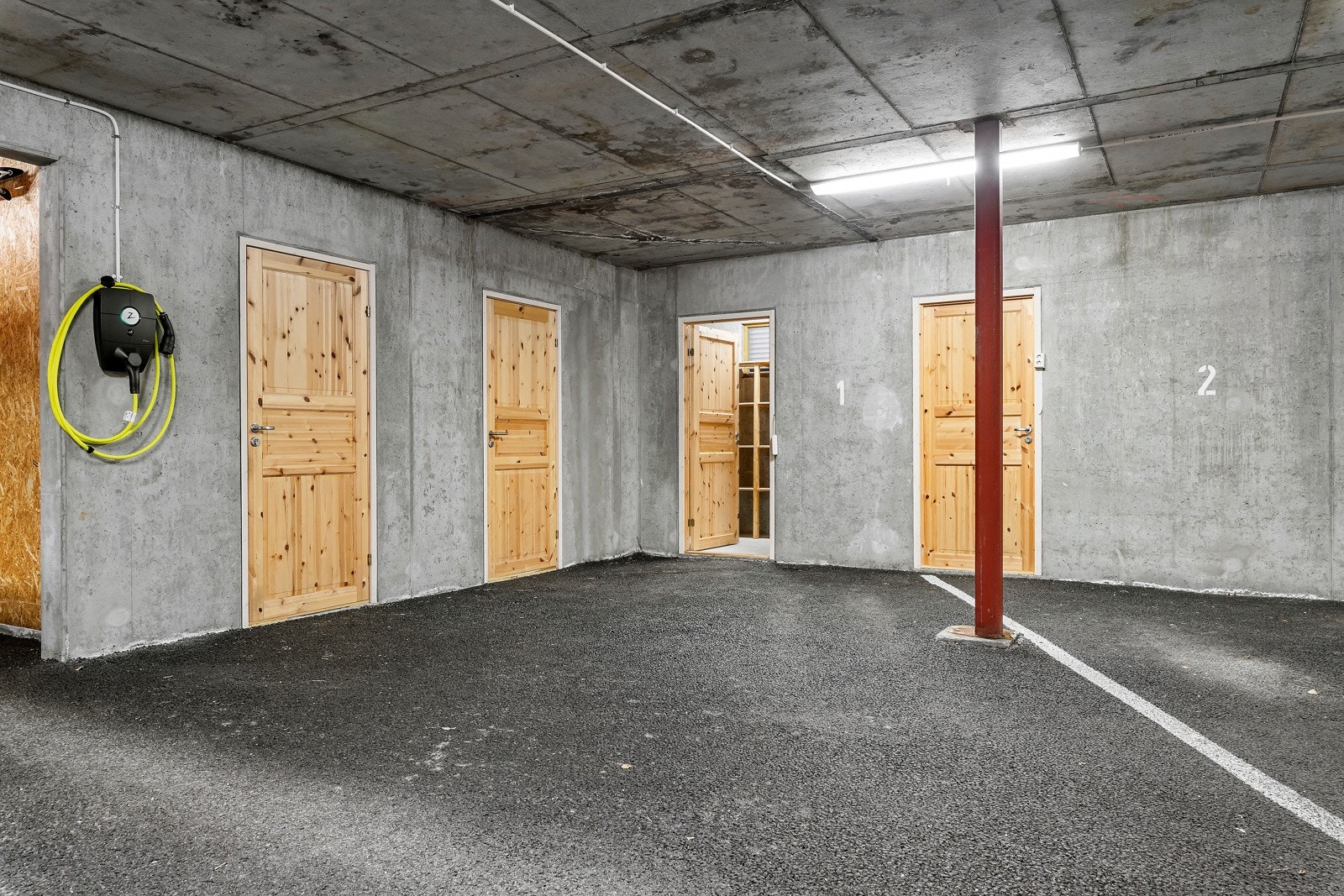 Egen parkeringsplass med bod i bakkant i parkeringsanlegget. Galleribilde