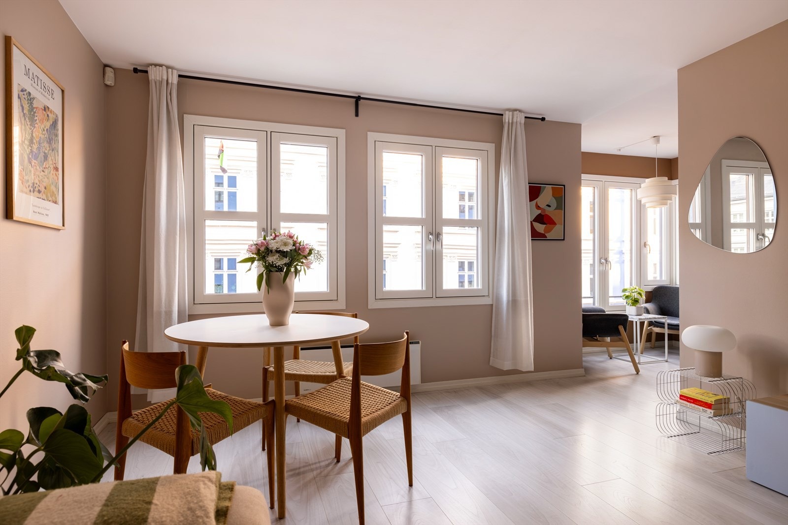 Lys og innbydende stue med laminatgulv og vegger malt i delikat fargetone (2022-2024). De mange vinduene, nylig byttet i 2024, slipper inn rikelig med naturlig lys, som skaper en trivelig atmosfære Galleribilde