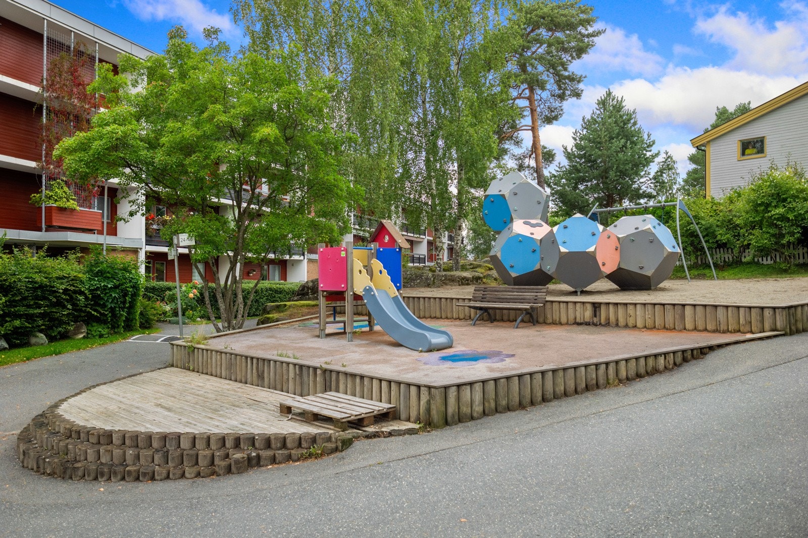 Fellesområdet er pent opparbeidet med asfalterte adkomstveier, lekeplass og grøntområder Galleribilde