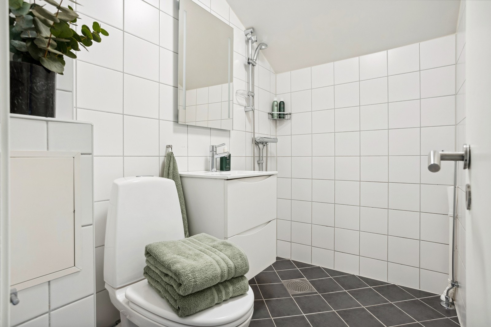 Flislagt bad med vamekabler i gulv, samt pen, nyere baderosinnredning. Galleribilde