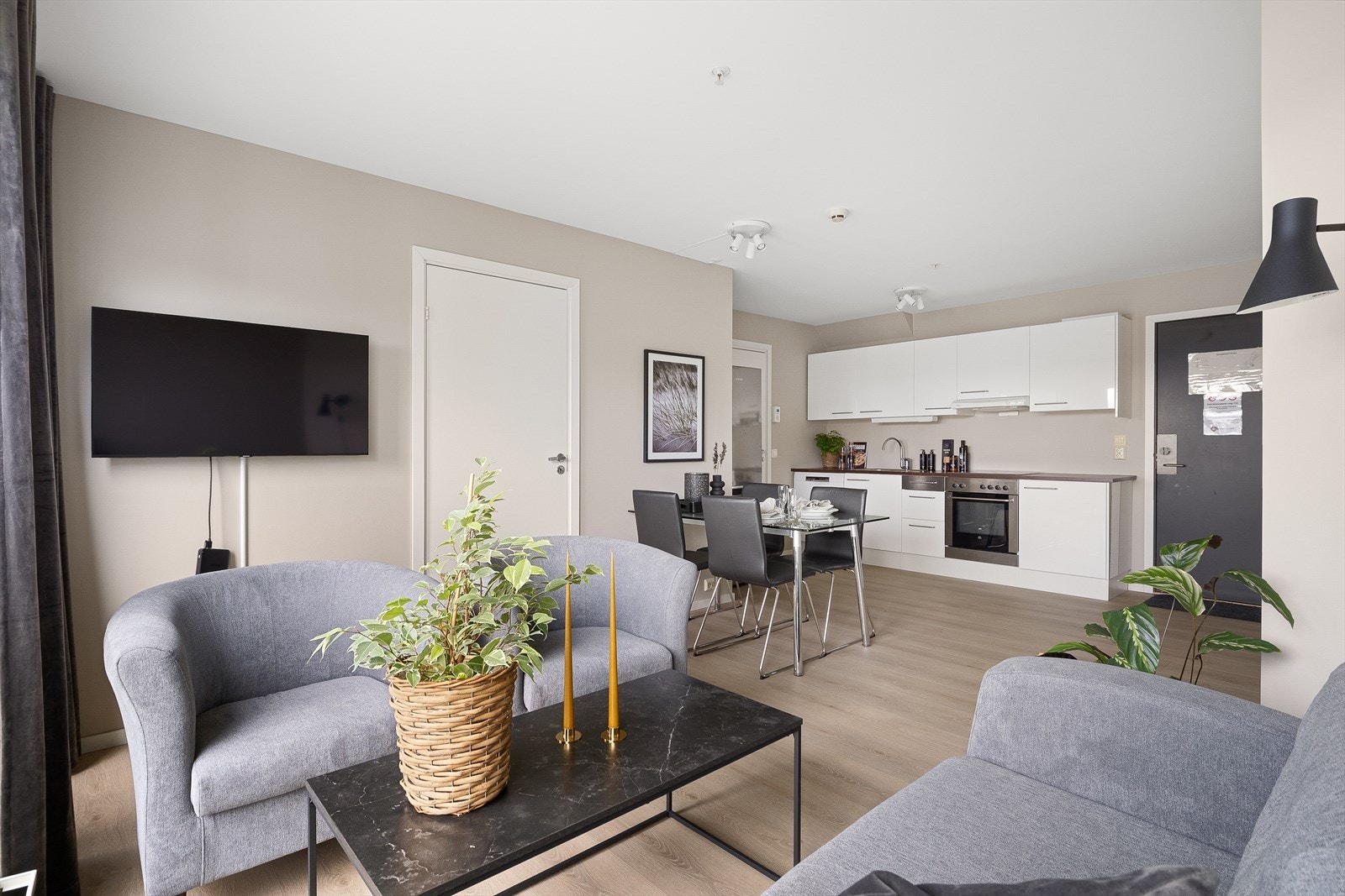 Stue og kjøkken i åpen løsning med plass til både sittegruppe og spisebord. Galleribilde