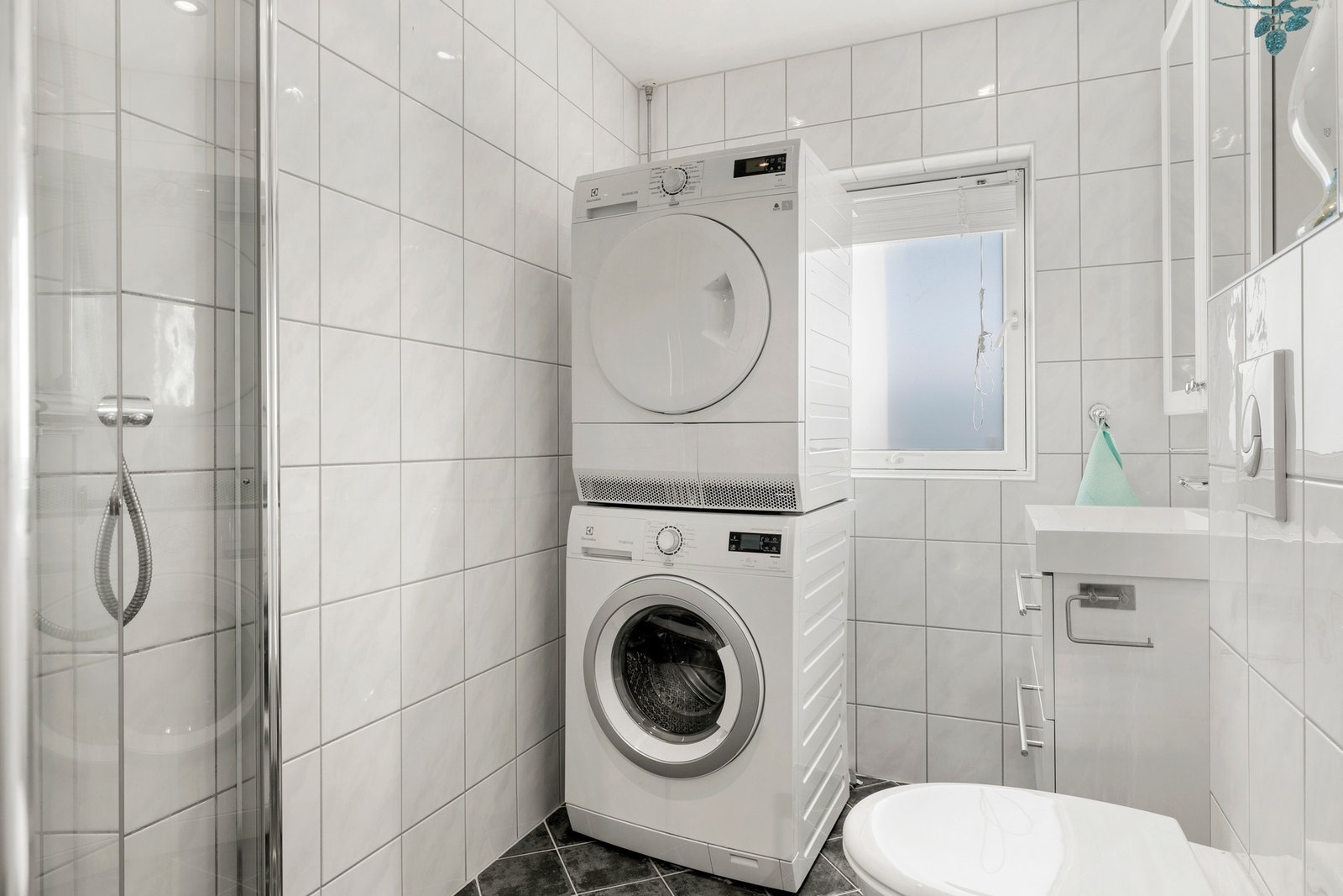Helfliset baderom med underliggende varmekabler og downlightsbelysning. Opplegg for vaskemaskin. Galleribilde