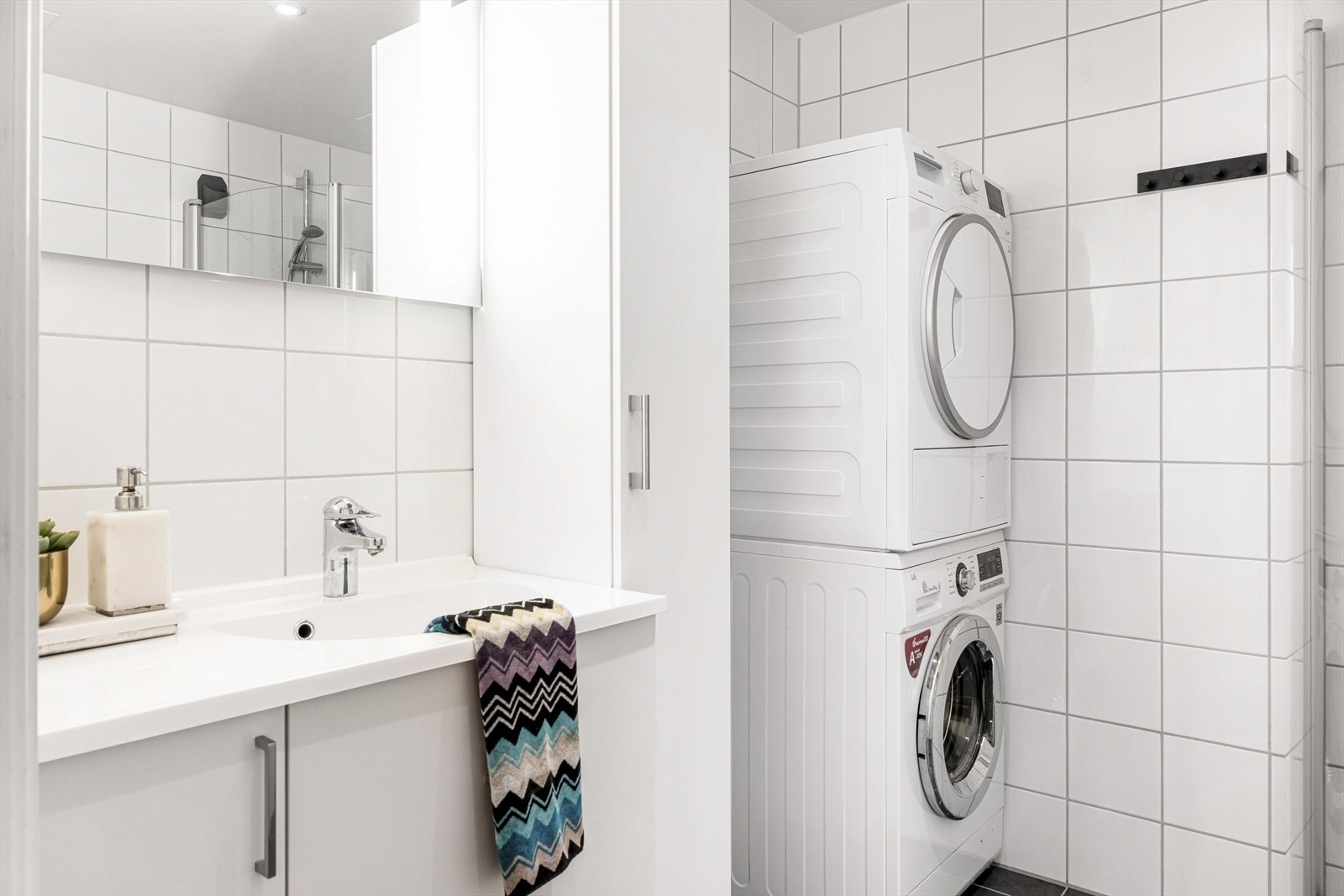 Badet er innredet med baderomsinnredning, høyskap, vegghengt toalett og dusj med glassdør. Det er opplegg for vaskemaskin og tørketrommel på badet. Galleribilde