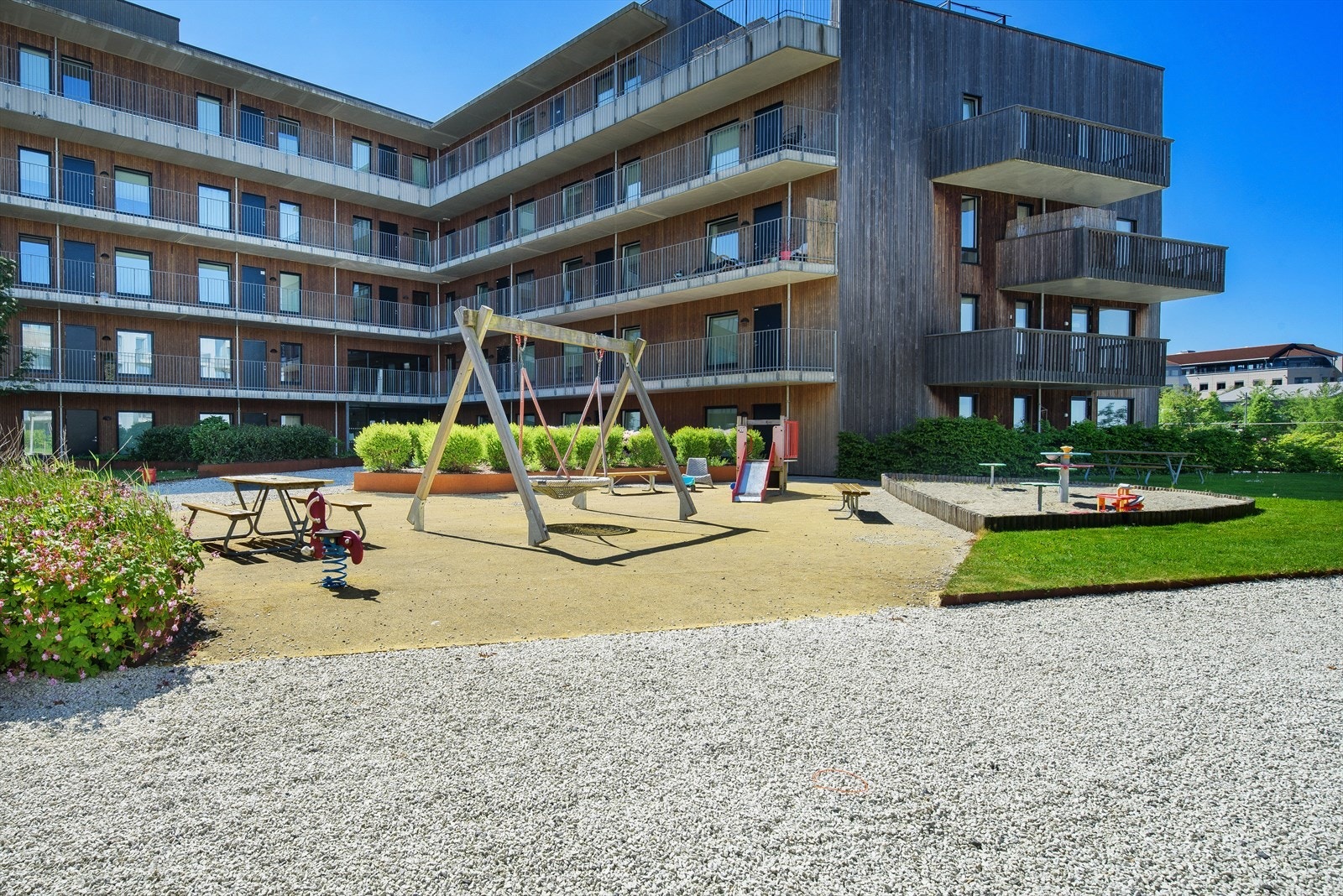 Leilighetsbygget er omkranset av flott uteområde med flere koselige lekeplasser, fint plenområde og felles sittegrupper Galleribilde