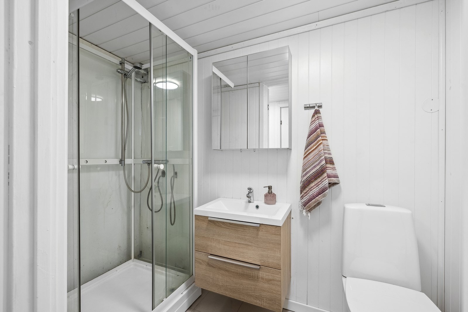 Bad 2 med dusjkabinett, servant med lagringsplass og toalett Galleribilde
