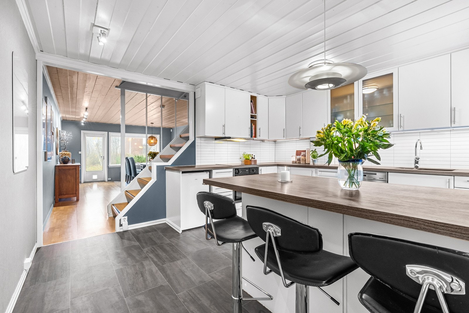 Kjøkkenet fungerer sømløst som husets hjerte, her tilberedes matpakker mens andre spiser, her gjøres lekser og her lages middager i fellesskap Galleribilde