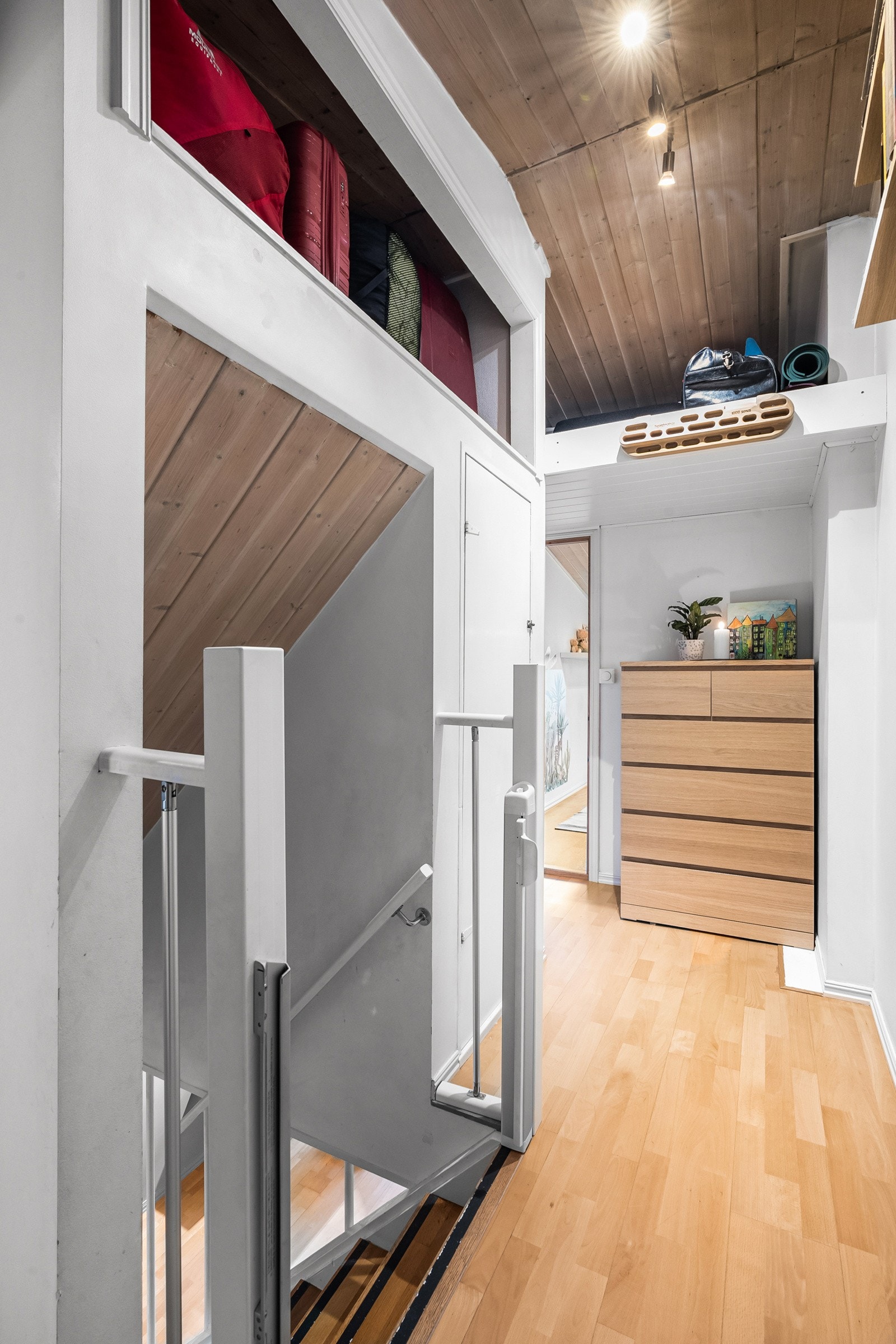 Videre kommer du opp til boligens 2.etasje. Trappen har integrert uttrekkbar barnegrind, og i gangen er det tilgang til lagringsplass på loft/hems Galleribilde