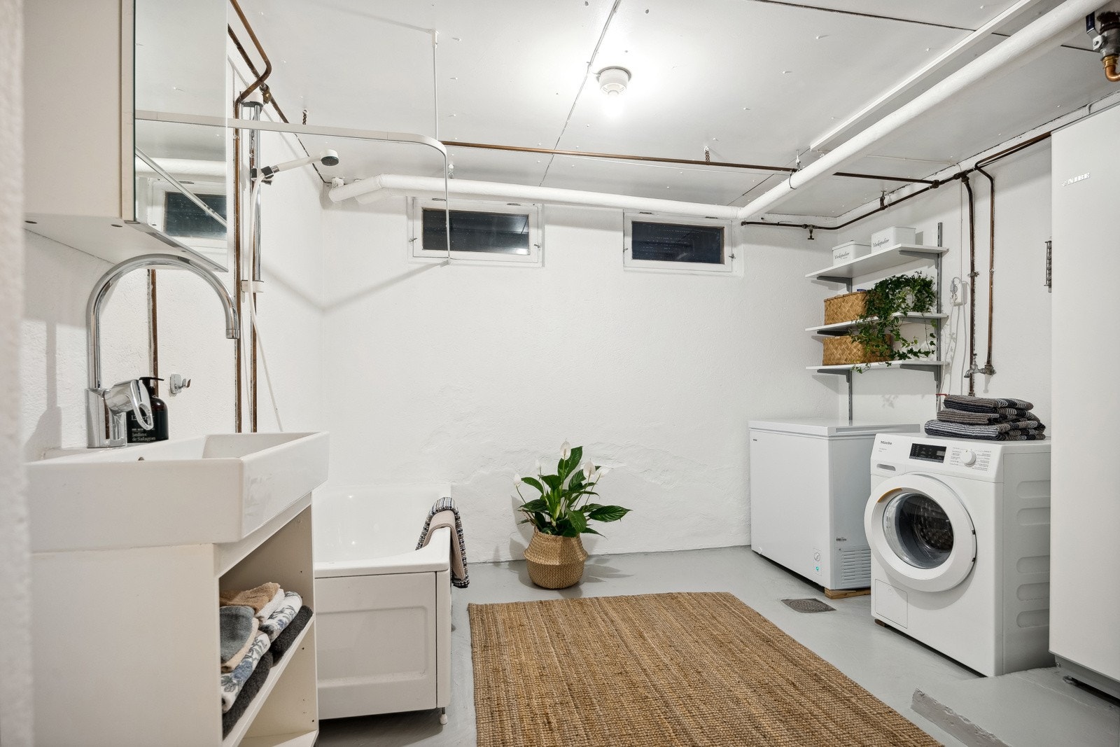 I kjelleretasjen finner man boligens separate vaskerom. Her er det innredet med vask og badekar, med god plass til vaskemaskin. Galleribilde