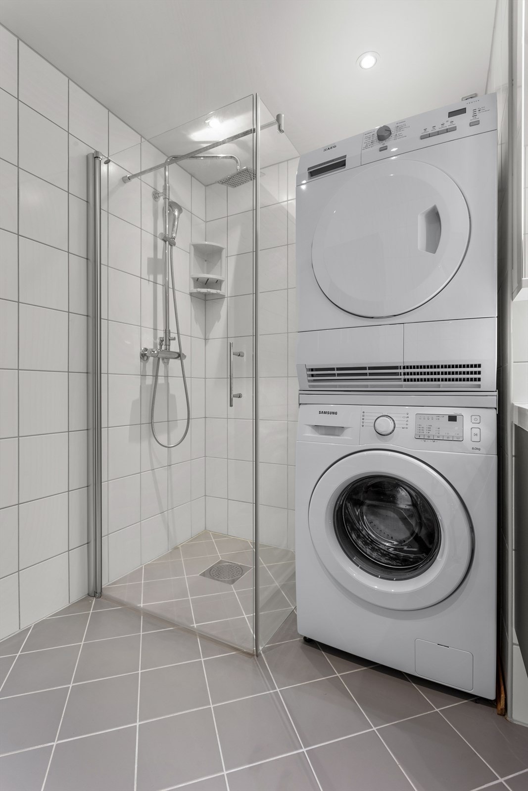 Dusjhjørne med glassdører og opplegg for vaskemaskin og tørketrommel Galleribilde