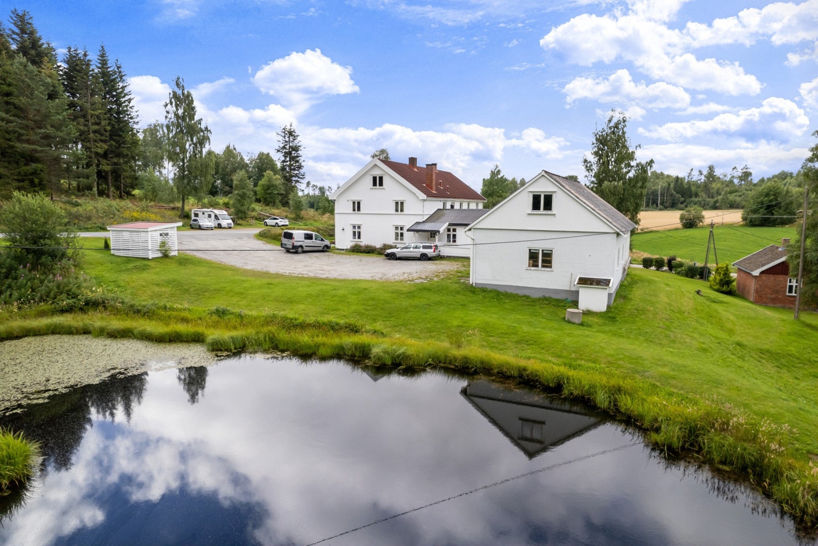 Dammen på tomten skaper en hyggelig stemning på eiendommen. Galleribilde
