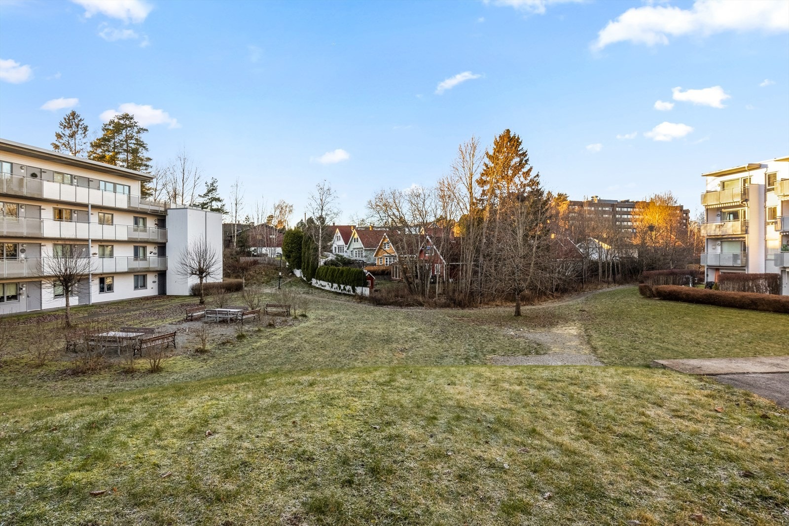 Tomten er pent opparbeidet med gressplen, beplantning og sittegrupper. Galleribilde