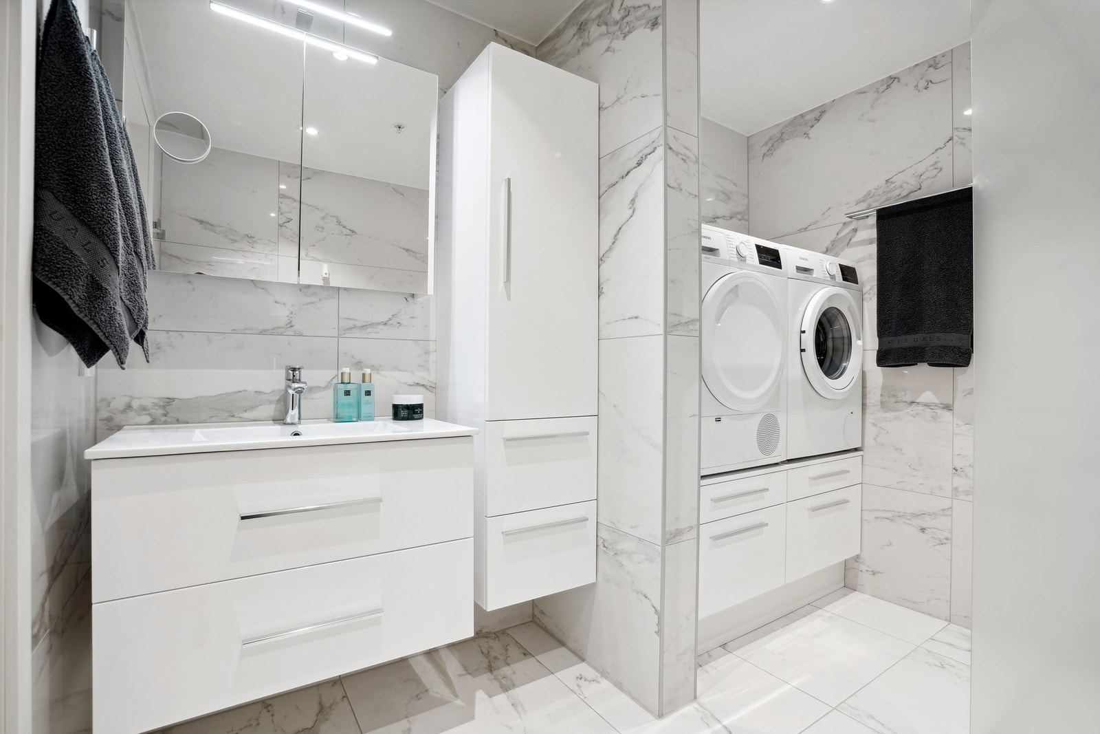 På hovedbadet finner du i tillegg praktiske skuffer under vaskemaskin og tørketrommel, som gir både funksjonalitet og et ryddig uttrykk. Galleribilde