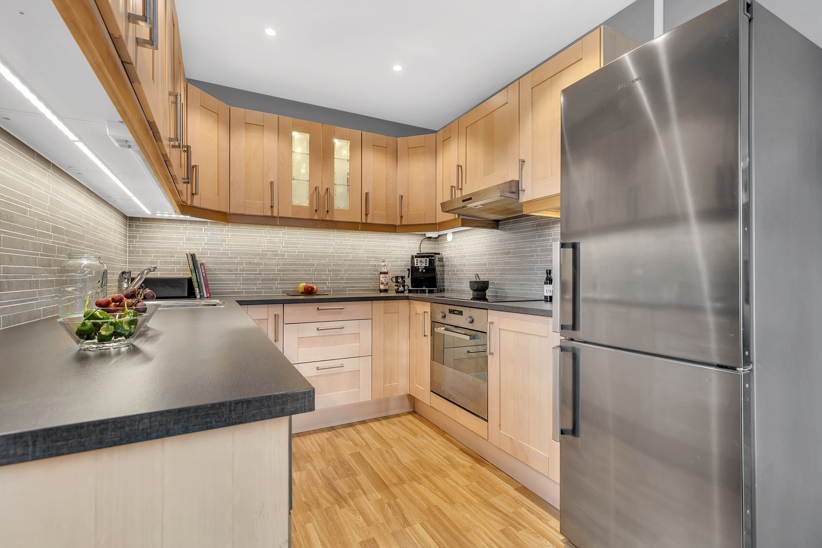 Stilrent kjøkken med mye skap og benkeplass. Galleribilde