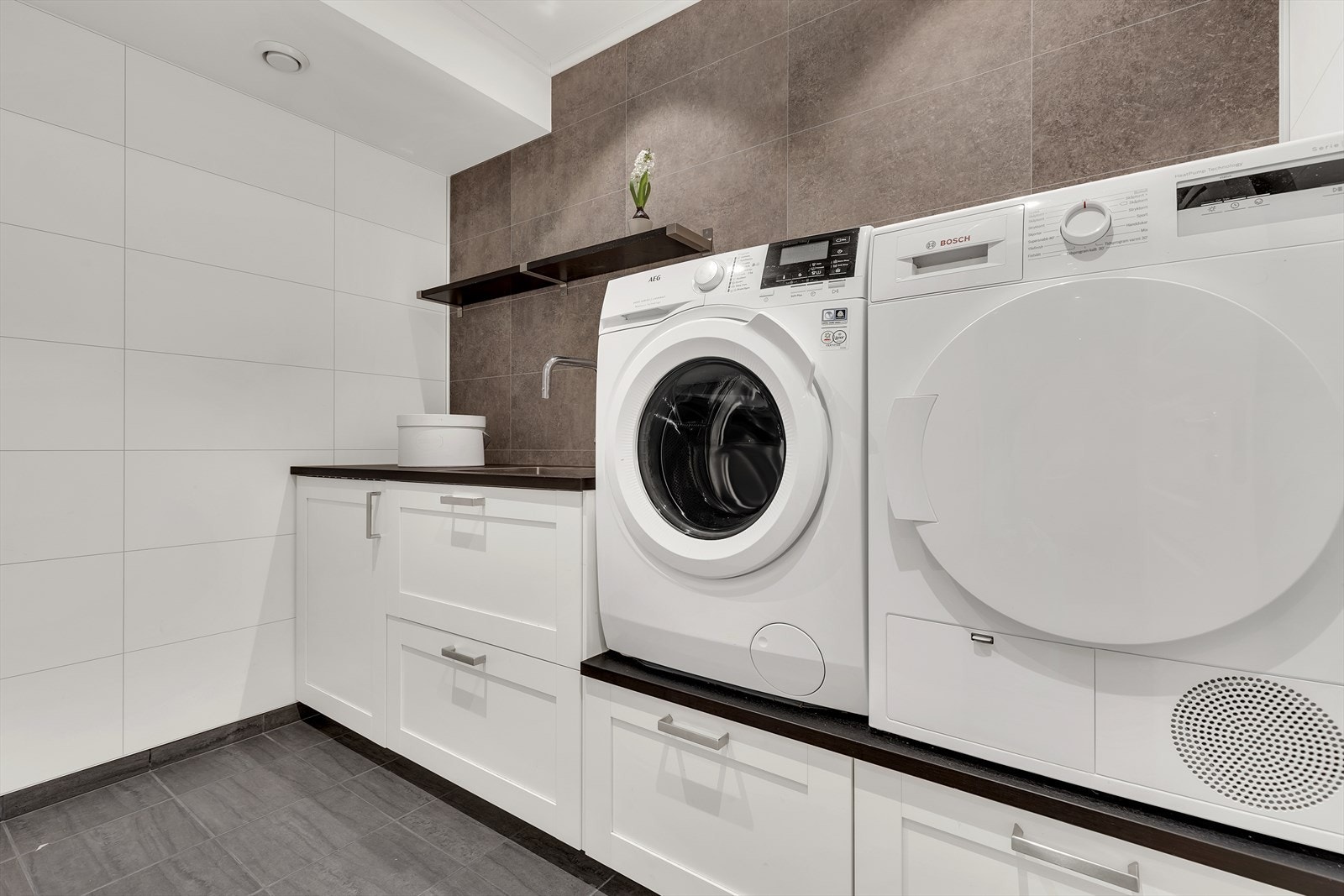 Pent flislagt vaskerom tilrettelagt for hvitevarer og mye lagringsplass. Oppusset i 2016. Galleribilde