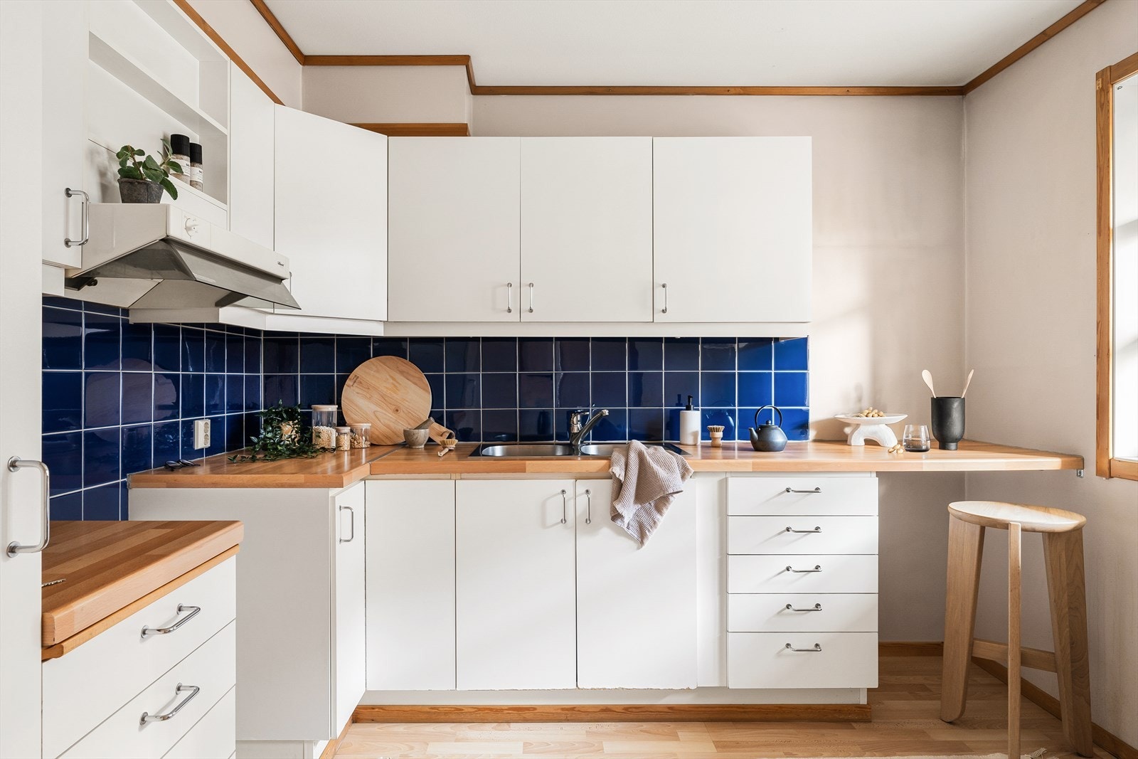 Lysarmatur med stikkontakt under overskap, og strømuttak på vegg for en praktisk arbeidsplass. Galleribilde