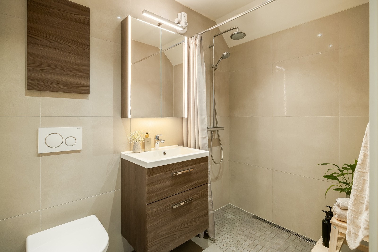 Lekkert bad fra 2019 med flislagte overflater, plastsluk og gulvvarme. Galleribilde