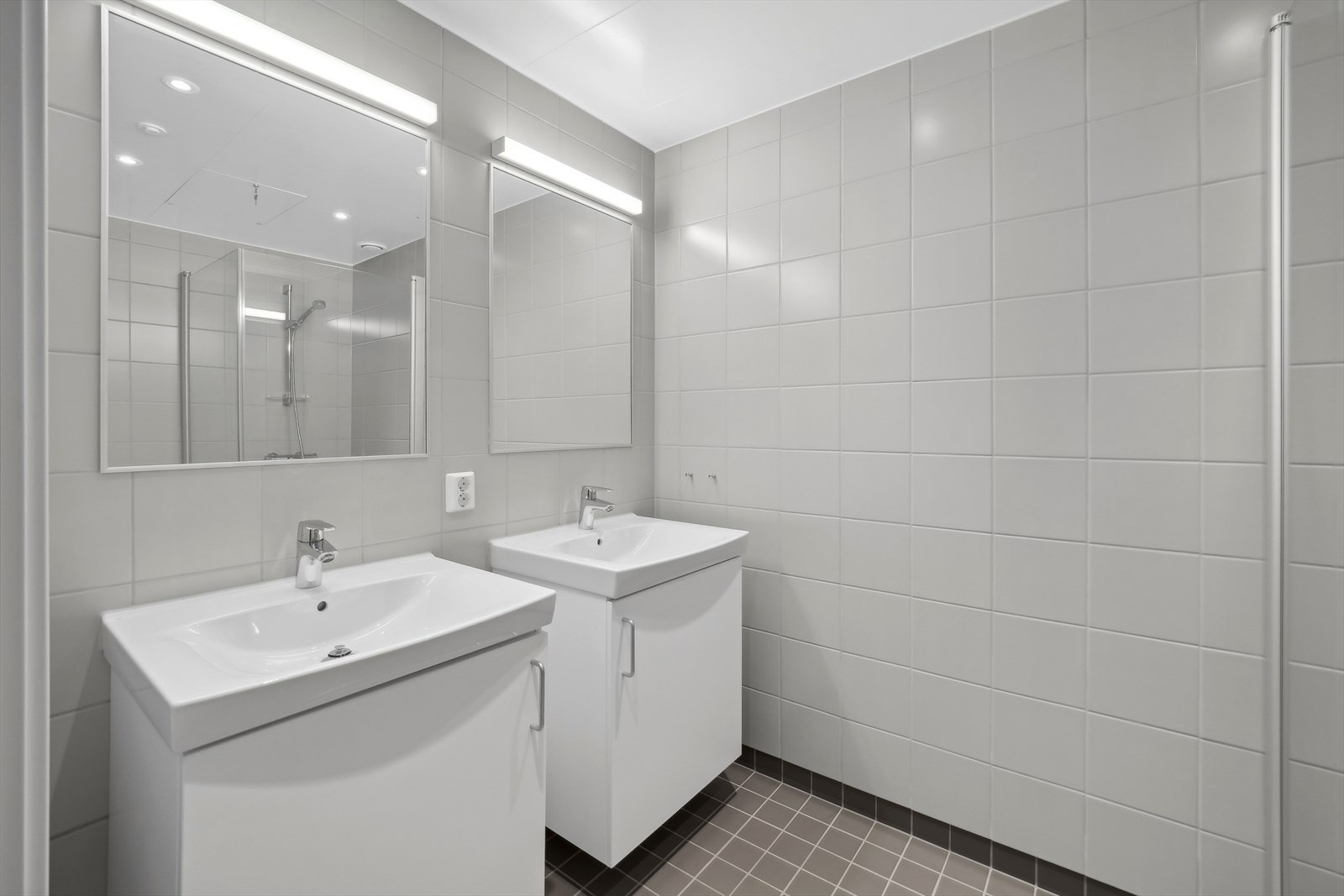 Flislagt baderom innenfor hovedsoverom med bl.a. dusj, 2 servanter og toalett. Galleribilde