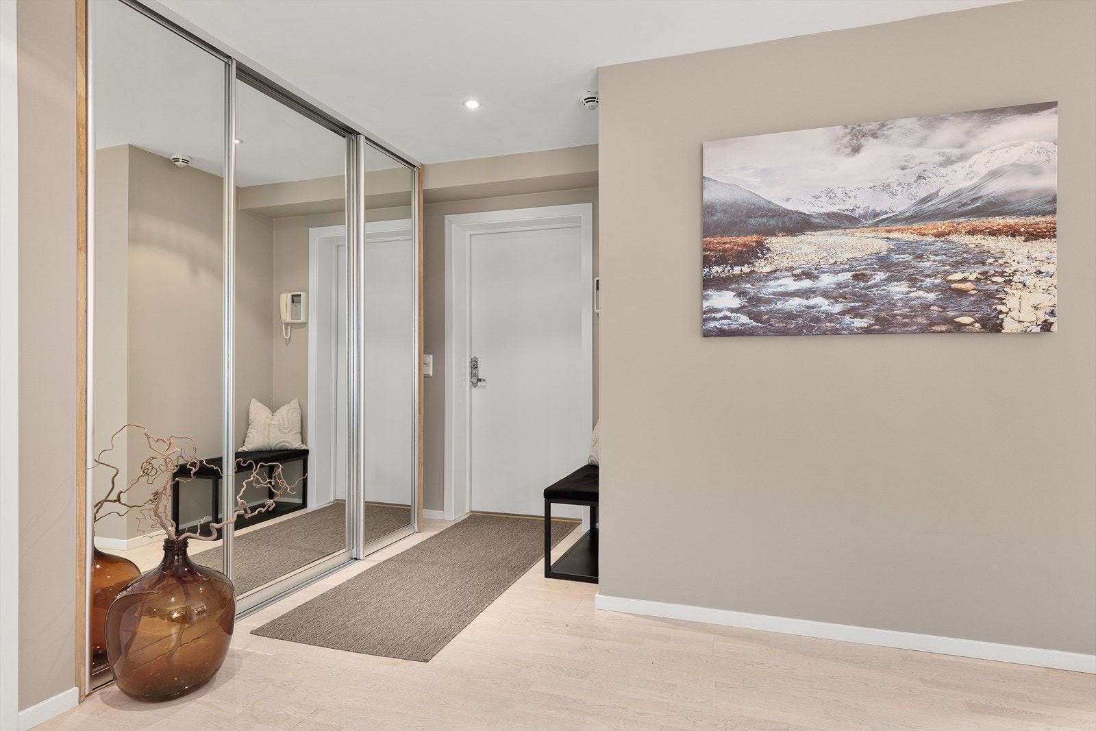Innbydende entré med god plass til å henge av seg yttertøy. Videre inneholder entreen en langsgående skyvedørsgarderobe med speilfronter samt porttelefon med kamerafunksjon Galleribilde