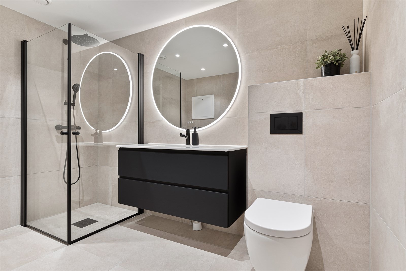 Lyst og pent bad fra 2024 med fliser med varme på gulv, fliser på vegg og malt slett himling med innfelte downlights Galleribilde