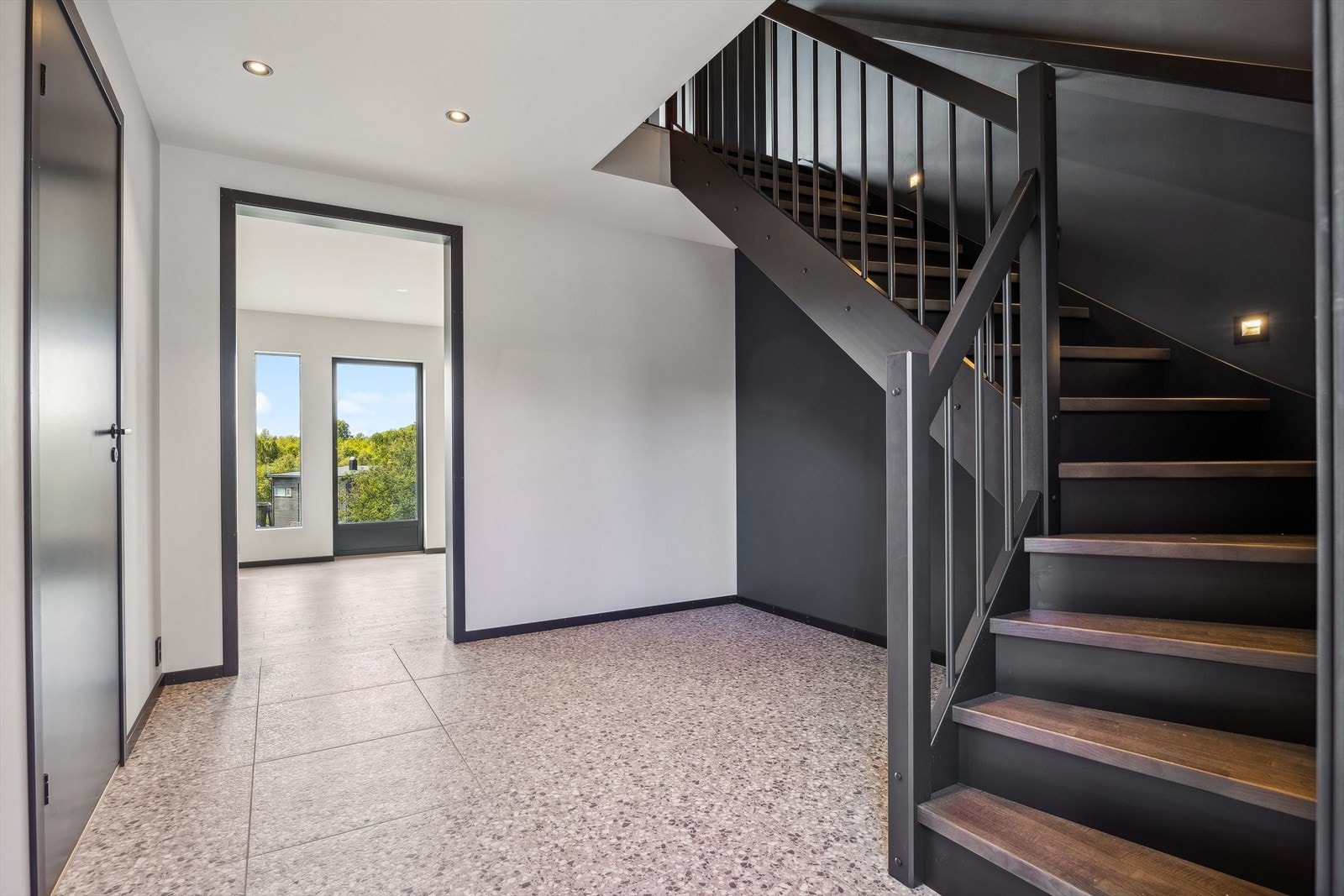 Velkommen inn. Tidsriktige tilvalg med svarte dører og listverk. Utstrakt bruk av downlights. Galleribilde
